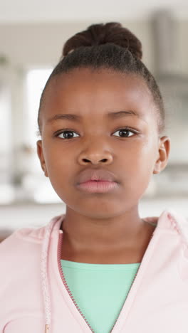 vertical video of portrait of happy african american girl smiling to camera, in slow motion