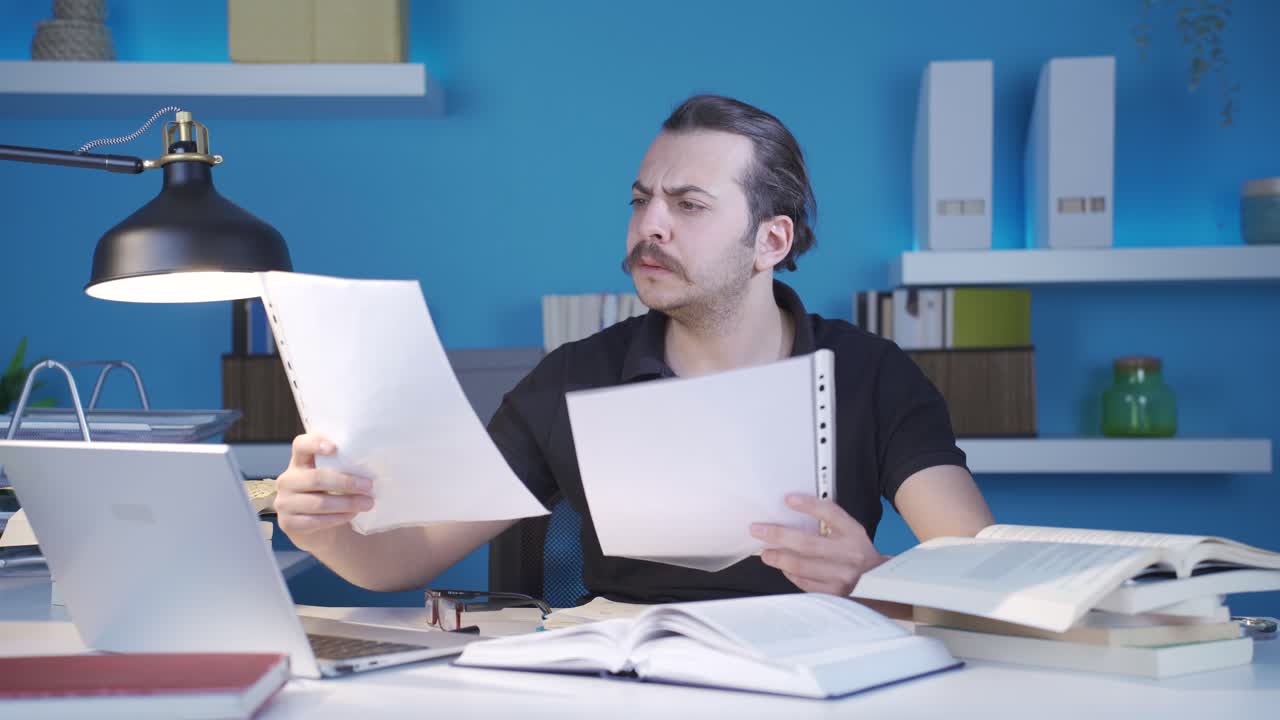 el hombre que mira papeles importantes está estresado y preocupado.