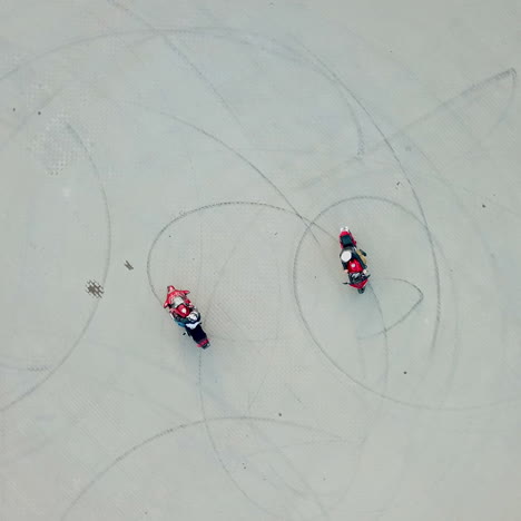 top view of two professional motobikers racing highspeed on a road in a circle way. bikers on their motorcycles training riding outdoors. aerial view.