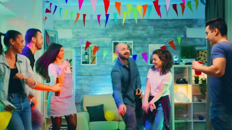 Attractive-young-woman-holding-a-balloon-while-dancing-with-her-friends