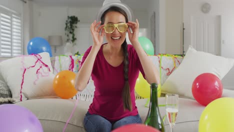 happy asian woman with party decorations making new year's eve laptop video call