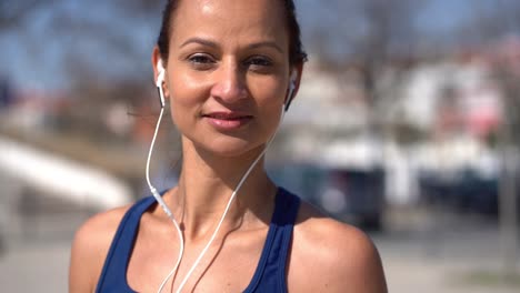 Retrato-De-Deportista-Con-Auriculares-Sonriendo-A-La-Cámara-Al-Aire-Libre