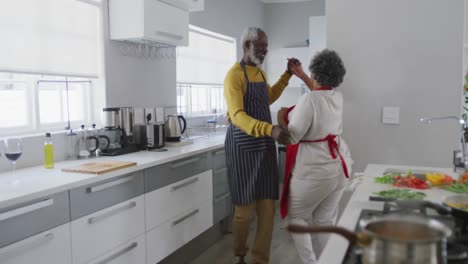 una pareja afroamericana mayor bailando en casa. distanciamiento social en cuarentena