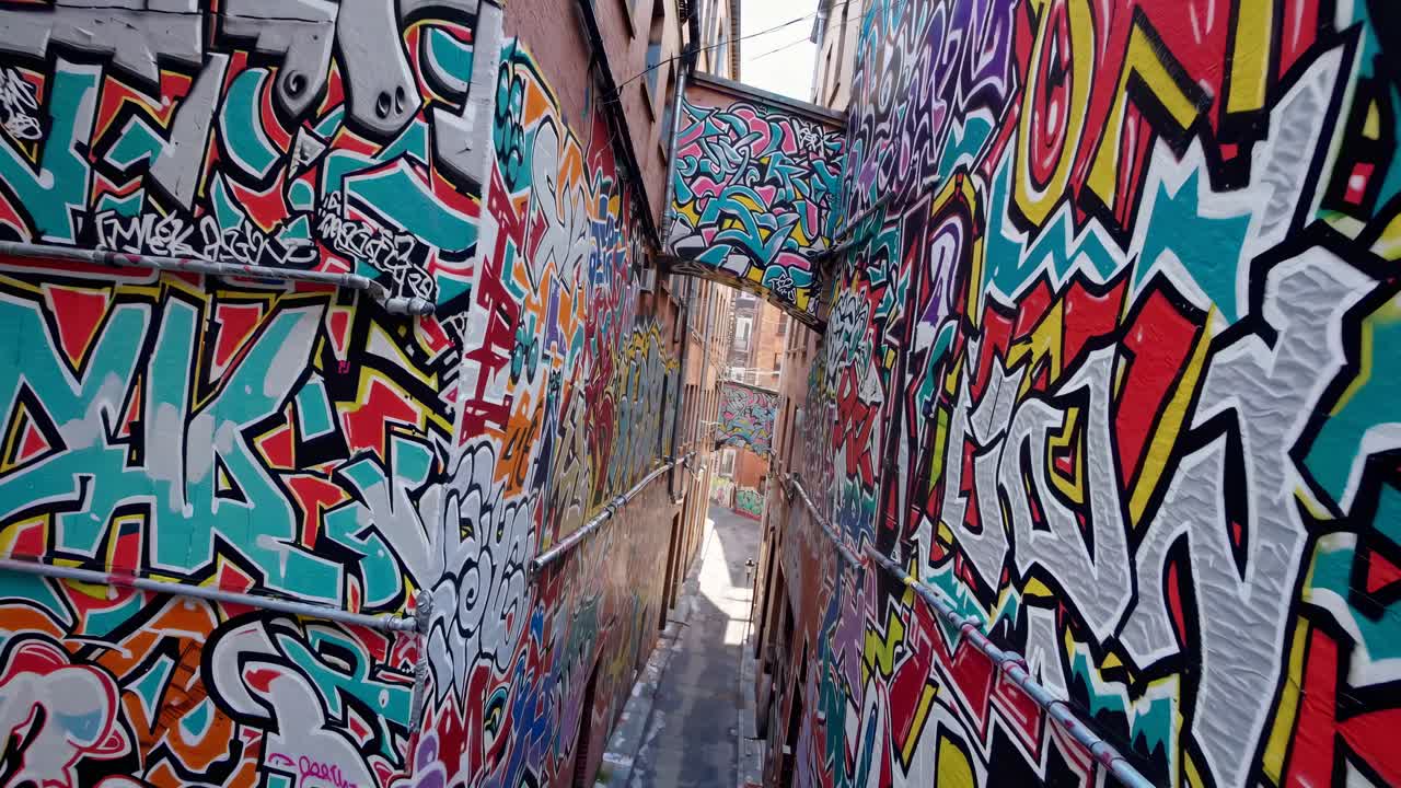 Graffiti vivaci coprono i muri del vicolo in un'inquadratura grandangolare, mettendo in mostra lo stile dinamico dell'arte urbana.