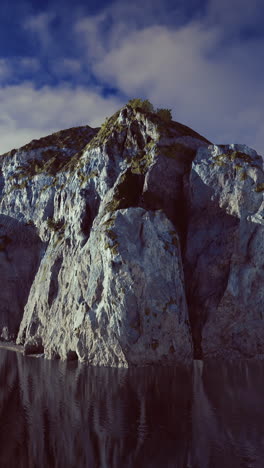 majestic rock formation reflects in calm waters under a vibrant sky
