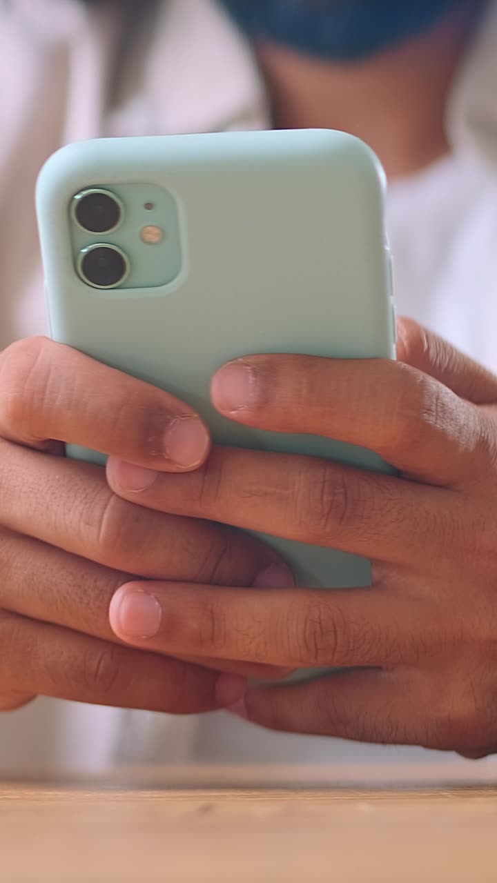 Closeup of mobile phone above table in hands of man using sms correspondence