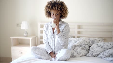 Woman-Drinking-A-Milk-On-Bed