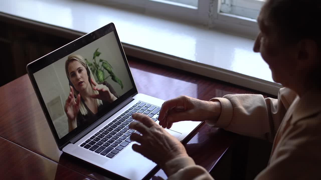 Senior woman make video call using laptop at home. COVID 19 Stay connected. Online chatting with assistants