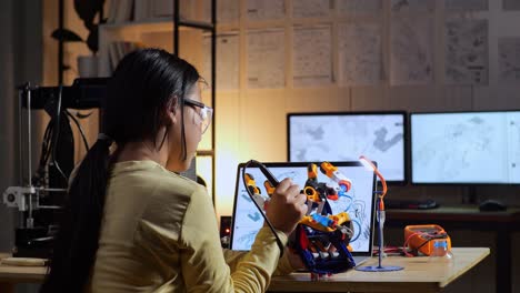 back view of teen asian girl repairing a cyborg hand at home