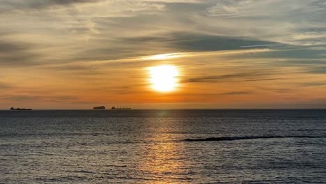 Beautiful-sunset-on-coastline-tropical-beach-with-golden-sea-and-silhouette-travel-people-on-nature-background-4K