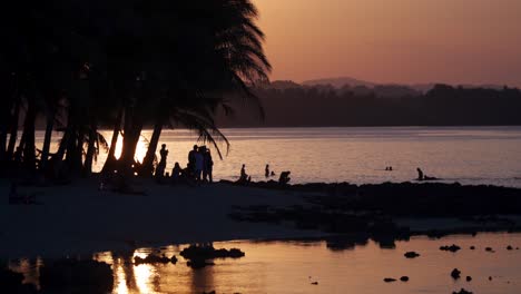 Gente-Disfrutando-Del-Agua-En-El-Fondo-Al-Atardecer