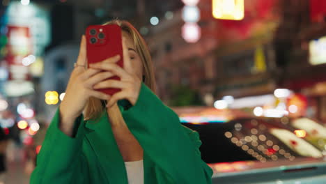 woman taking a picture at night in a city