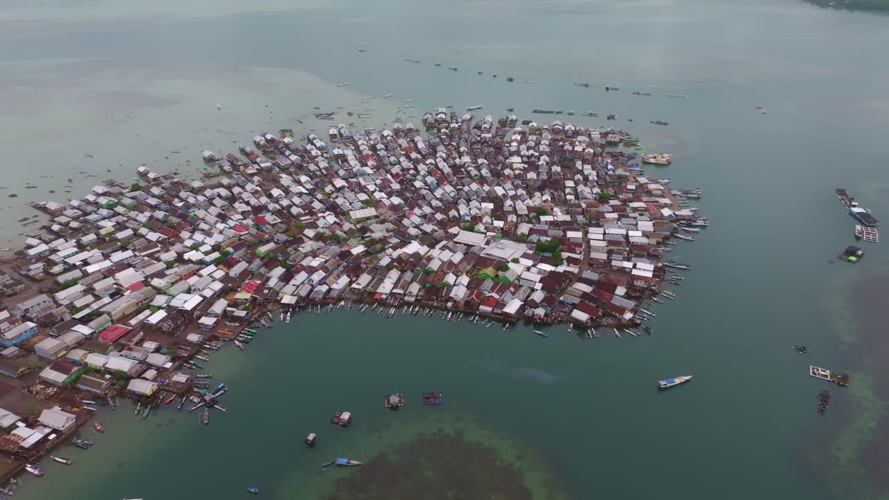 Pemukiman tepi laut yang dipenuhi kapal nelayan dan rumah-rumah, Sumbawa, Indonesia
