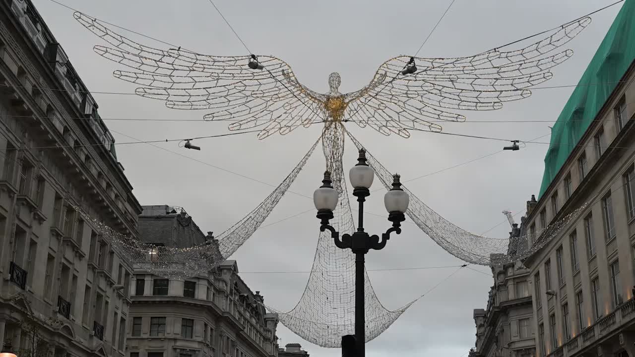 Festive lights fill Regents Street during Christmas creating a joyful atmosphere above the busy shopping avenue