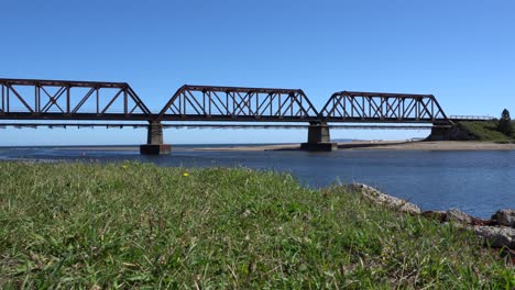 Eine-Stählerne-Eisenbahnbrücke,-Auf-Der-Man-In-Der-Ferne-Vier-Räder-Sehen-Kann,-Die-Sich-Darauf-Bewegen