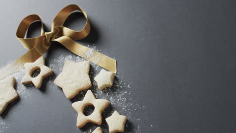 video of christma star cookies decorated with sugar and ribbon, copy space on black background