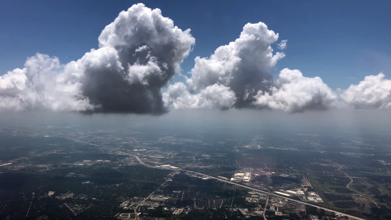 Vista aérea de nubes esponjosas moviéndose sobre un paisaje urbano