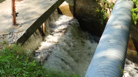 El-Agua-Cae-Suavemente-En-Cascada-A-Través-De-Una-Pequeña-Presa-Artificial-Frente-A-Una-Alcantarilla