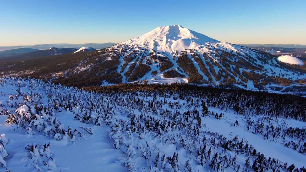 una toma aérea captura la montaña al amanecer, bañada en impresionantes alpenglow