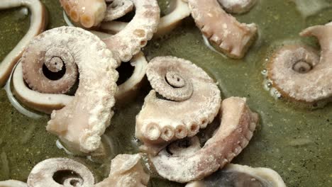 close up of octopus being fried in a pan