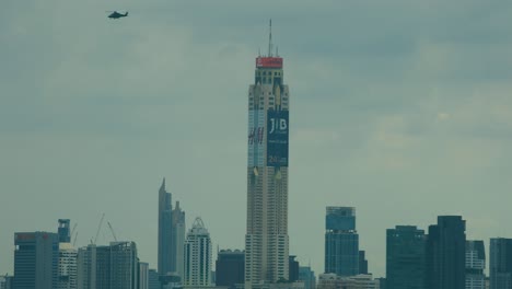 Königlicher-Thailändischer-Militärhubschrauber,-Der-In-Atemberaubendem,-Echtem-4K-DCI-über-Der-Skyline-Von-Bangkok-Schwebt