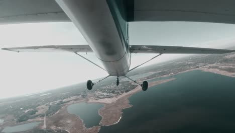 light aircraft cessna 150 turning over lake near suburban residential area.