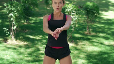 athlete woman training jump and squat while workout outdoor in summer park