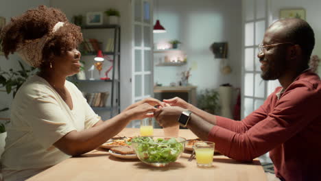 african american couple praying before eating meal