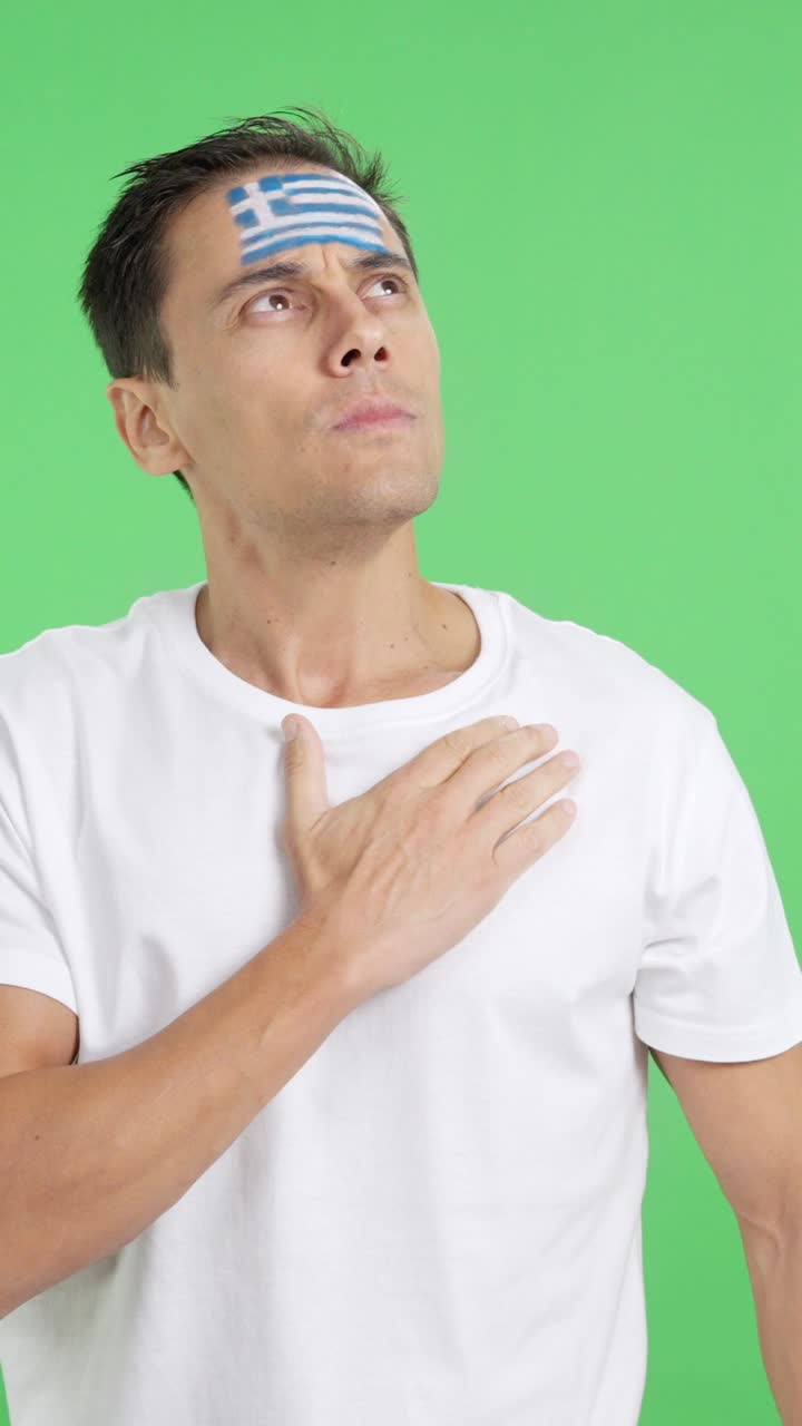 Man listening to the Greece national anthem with solemnity