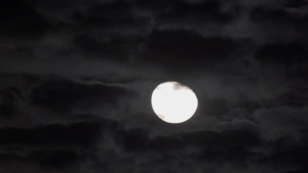 Linda lua cheia cruzando o céu, nuvens passando à frente