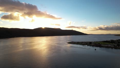 hermosa puesta de sol detrás de la silueta negra de las montañas en ullapool en un día parcialmente nublado