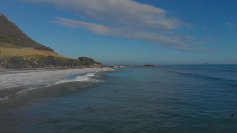 AERIAL:-Surfers-at-Mount-Maunganui-Beach,-New-Zealand