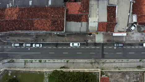 top bird's eye shot of a small brazilian street with cars and motorcycles parked and driving by in the historic downtown of the coastal capital city of joao pessoa, paraiba, brazil during golden hour
