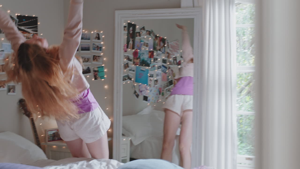 행복한 십대 소녀가 침실에서 음악에 맞춰 춤을 추고 주말을 축하하고 재미있게 노래하며 집에서 파자마를 입고
