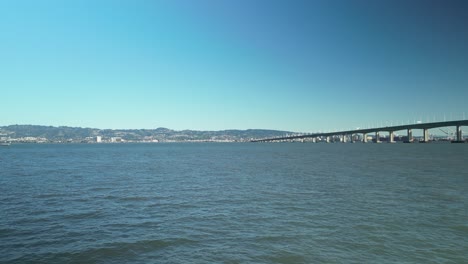 push in drone shot of san francisco-oakland bay bridge with pacific ocean and blue sky in california, usa