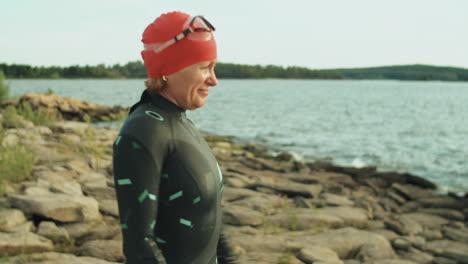 female triathlete warming up before swimming in lake