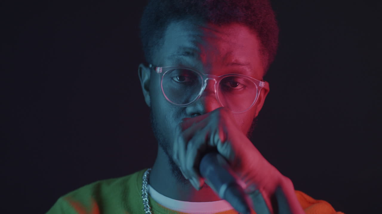 hombre actuando con micrófono en la iluminación de neón