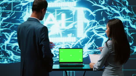 startup coworkers looking over charts, using ai software on mockup laptop