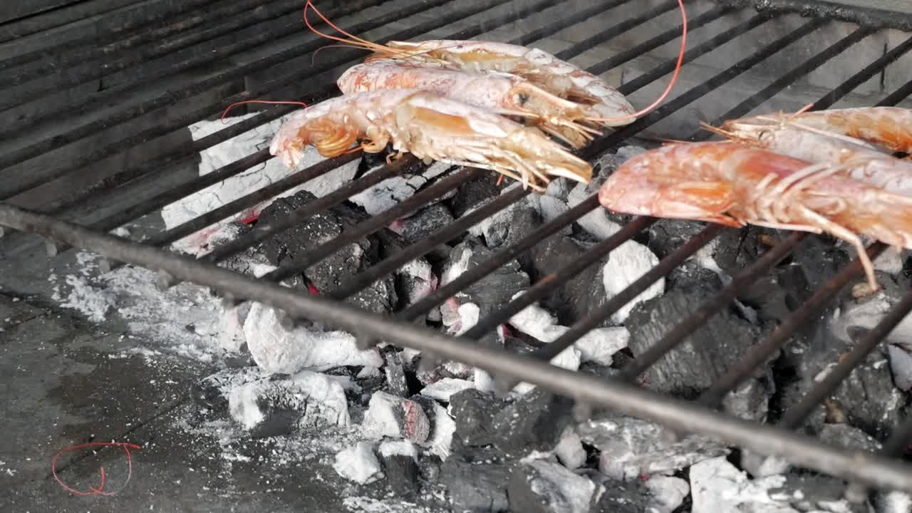 Grilled tiger prawns over hot charcoal with a rustic and smoky outdoor vibe