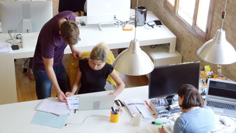 business people discussing over documents at desk