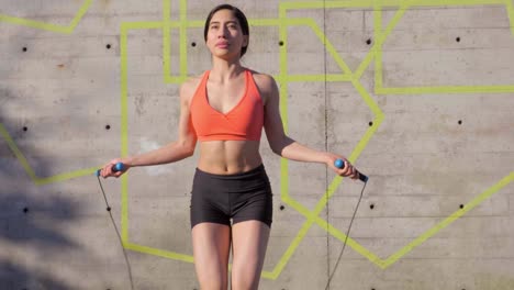mujer hispana milenaria usando cuerda para saltar en parque urbano, tiro medio