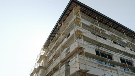 building under construction with scaffolding and workers