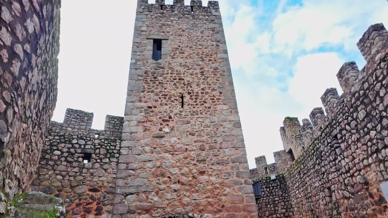 Mura della fortezza del Convento di Cristo a Tomar, Portogallo. Merlature in pietra consumata e architettura medievale rivelano un punto di riferimento storico del patrimonio UNESCO, panoramica manuale in ascesa