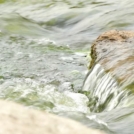 fast flowing river with stones in the water