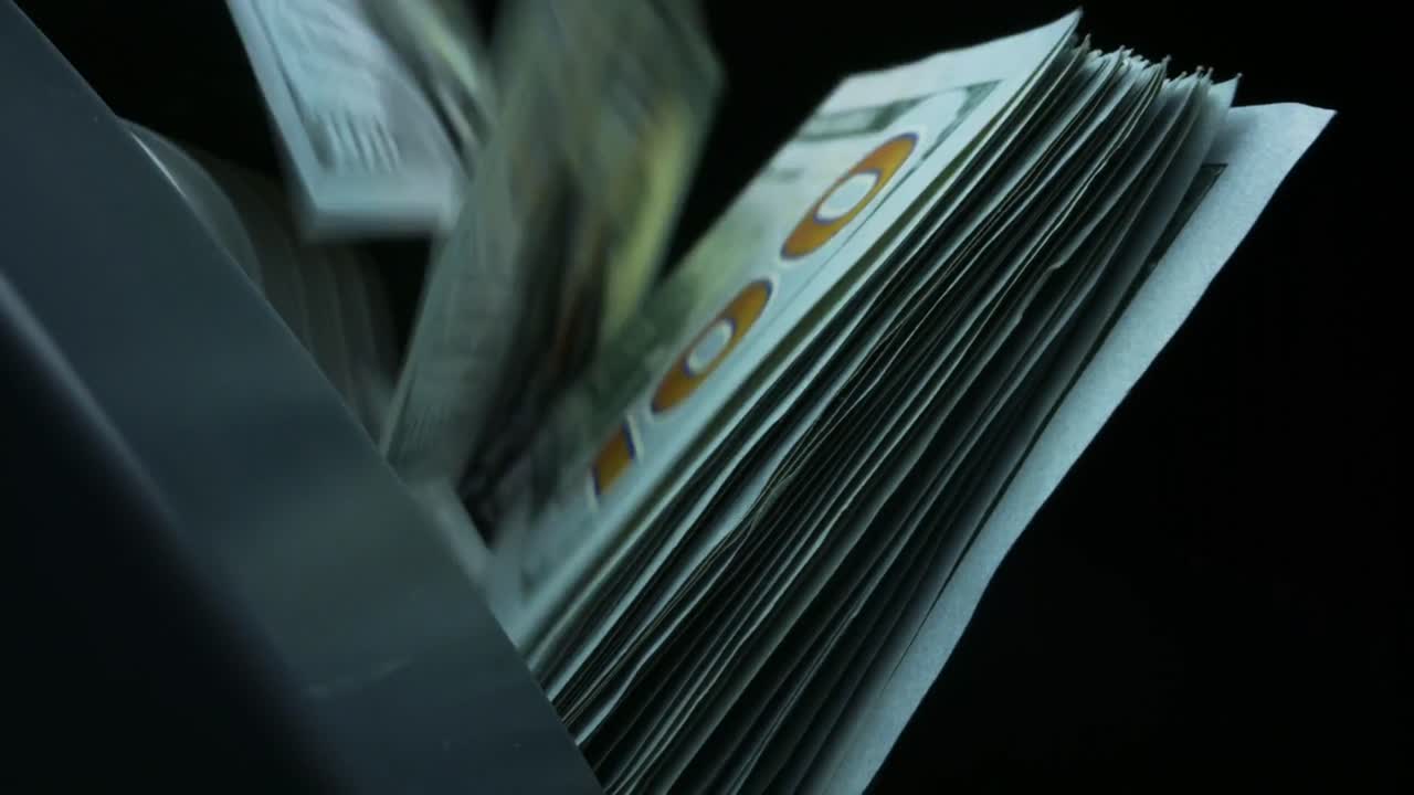 Processus de comptage de l’argent dans une pièce sombre avec des mouvements rapides