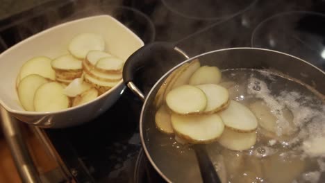 slow motion steaming hot potatoes being taken out of boiling pot of water in a kitchen. hd 1080p 23.98p