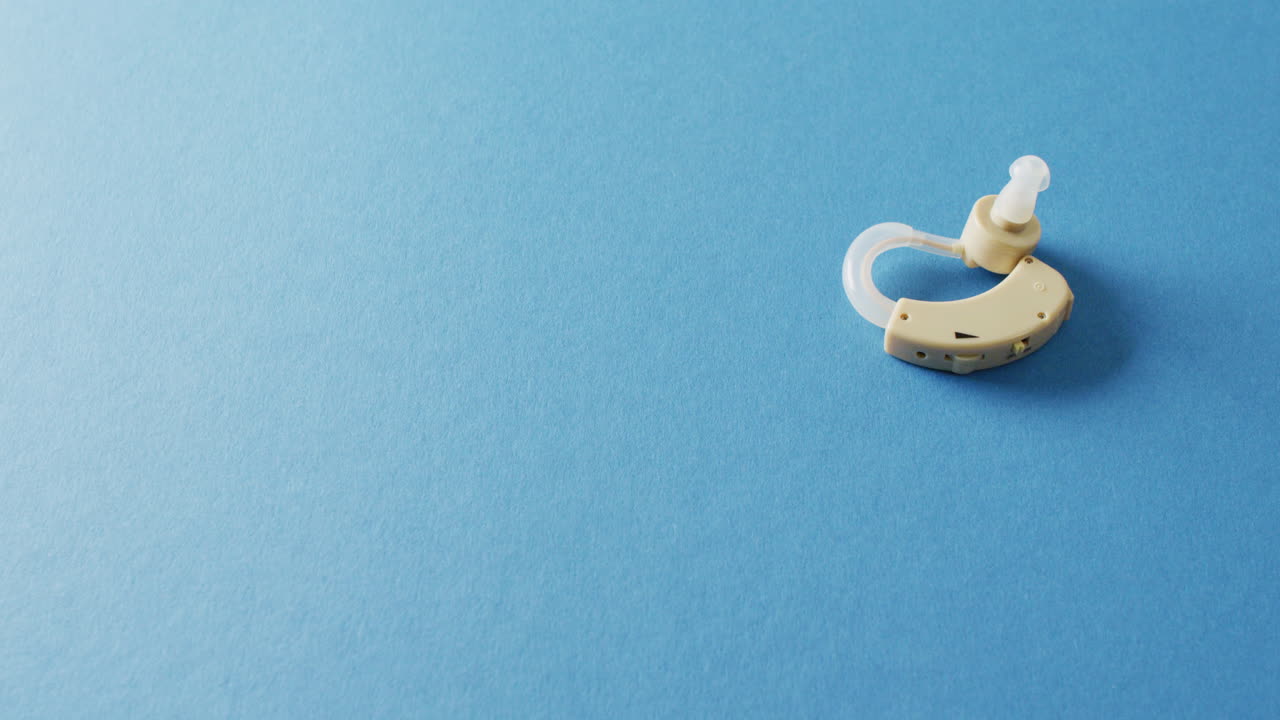 Video of hearing aid on blue background with copy space