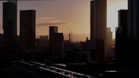 The-Sunrises-over-Deansgate-Square,-a-residential-skyscraper-cluster-on-the-southern-edge-of-Manchester-City-Centre,-UK-They-are-called,-North,-West,-South-,East,-The-Blade,-Beetham-Tower-and-Three60