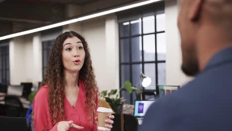 two happy diverse creative colleagues in discussion in casual office, slow motion