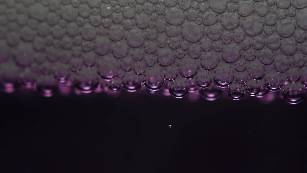 보라색 액체에 비누 거품의 근접 촬영